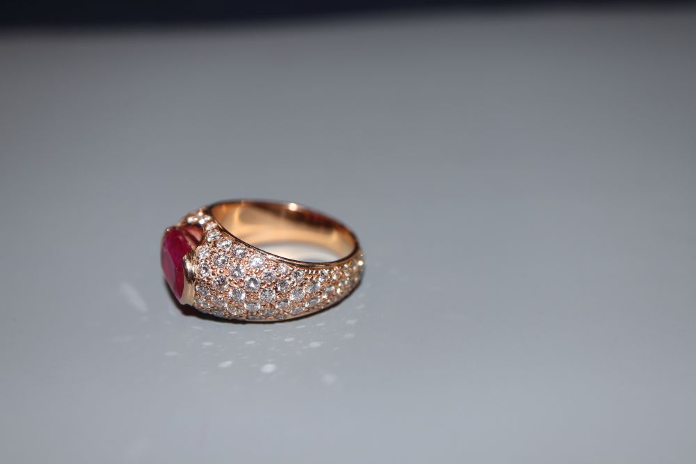 A yellow metal, ruby and diamond encrusted dress ring, size O, gross 11.3 grams.